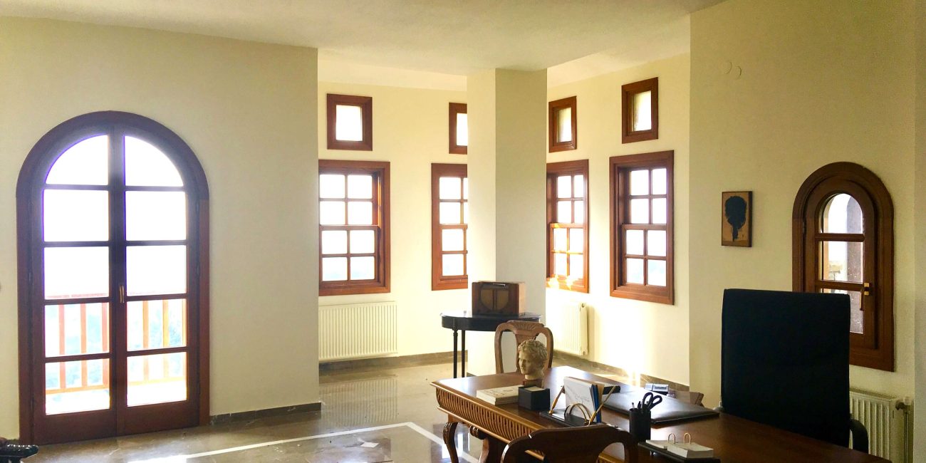 Large room with many windows, a desk and chair